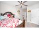 Bedroom with a wooden bed frame, ceiling fan, carpet flooring and doorway to other rooms at 614 Marian Way, Sanford, NC 27330