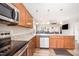 Modern kitchen with stainless steel appliances and wood cabinets overlooks a spacious living area at 614 Marian Way, Sanford, NC 27330