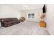 Open living area with carpet, a leather sofa, armchair, and a mounted TV above a cabinet at 614 Marian Way, Sanford, NC 27330