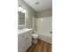 Well-lit bathroom with a tub and shower combo, white vanity, and wood-look floors at 621 Reservoir St, Durham, NC 27703