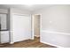 Hallway with wood-look flooring, wainscoting, and closet with bi-fold doors at 621 Reservoir St, Durham, NC 27703