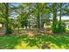 A green backyard with mature trees, a fenced perimeter, and a pool in view at 63 Majestic Oak Dr, Garner, NC 27529