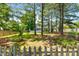 A lush backyard with mature trees, a pool, and a charming picket fence at 63 Majestic Oak Dr, Garner, NC 27529