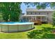 Large backyard featuring an above-ground pool, lush lawn, and a gray home at 63 Majestic Oak Dr, Garner, NC 27529