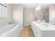 Bright bathroom with double sinks, a large tub, and separate glass shower at 63 Majestic Oak Dr, Garner, NC 27529