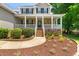 Charming brick home featuring a welcoming front porch with white columns and meticulously maintained landscaping at 63 Majestic Oak Dr, Garner, NC 27529