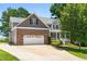 Charming two-story home features a brick facade, attached garage, and landscaped front yard at 63 Majestic Oak Dr, Garner, NC 27529
