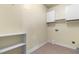 Laundry room features built-in storage cabinets, shelving, and tile floors at 63 Majestic Oak Dr, Garner, NC 27529