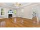 Sunlit living room featuring gleaming hardwood floors, a cozy fireplace, and a classic ceiling fan at 63 Majestic Oak Dr, Garner, NC 27529