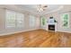 Bright living room featuring hardwood floors, a fireplace, and large windows at 63 Majestic Oak Dr, Garner, NC 27529