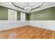 Green living room with hardwood floors, tray ceiling, and large windows at 63 Majestic Oak Dr, Garner, NC 27529