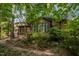 Home exterior featuring a wooden deck, a pergola, and lush greenery all around at 6700 Falconbridge Rd, Chapel Hill, NC 27517