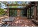 Spacious brick back patio with pergola, glass table, and sliding glass door entrance at 6700 Falconbridge Rd, Chapel Hill, NC 27517