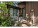 Back patio with glass sliding door entrance into home, surrounded by lush greenery at 6700 Falconbridge Rd, Chapel Hill, NC 27517