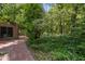 Home features brick walk-way and lush green ground cover that leads to a shaded back yard at 6700 Falconbridge Rd, Chapel Hill, NC 27517