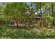 Exterior shot of home surrounded by trees and shrubs with a patio in view at 6700 Falconbridge Rd, Chapel Hill, NC 27517