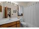Bathroom with wooden cabinets, lighted mirror and a shower-tub combination, providing functionality at 6700 Falconbridge Rd, Chapel Hill, NC 27517