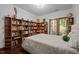 Bedroom featuring extensive built-in bookshelves and a cozy, inviting atmosphere with a window at 6700 Falconbridge Rd, Chapel Hill, NC 27517