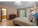 Bedroom features hardwood floors, light peach walls, sliding glass doors and en-suite bathroom at 6700 Falconbridge Rd, Chapel Hill, NC 27517