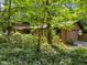 Cozy home with green trim surrounded by lush trees and bushes at 6700 Falconbridge Rd, Chapel Hill, NC 27517