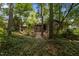 Exterior shot of home surrounded by trees and shrubs with a back patio in view at 6700 Falconbridge Rd, Chapel Hill, NC 27517