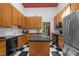 Kitchen features black and white flooring, wood cabinets, stainless steel refrigerator, and black appliances at 6700 Falconbridge Rd, Chapel Hill, NC 27517