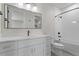 Modern bathroom with white cabinets, black fixtures, a shower, and a large mirror at 730 Hopkins St, Durham, NC 27701