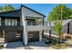 Modern home with a sleek exterior, balcony, and a gray garage door at 730 Hopkins St, Durham, NC 27701