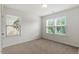 Bedroom with a large window showing outside view, neutral paint, and carpet flooring at 7879 Allscott Way, Raleigh, NC 27612