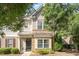 Charming townhome featuring a stone and shake facade, a black front door, and beautifully landscaped grounds at 7879 Allscott Way, Raleigh, NC 27612