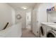Bright hallway features a laundry closet with a washer and dryer, and decorative mirror at 7879 Allscott Way, Raleigh, NC 27612