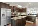 Modern kitchen with dark cabinets, stainless steel appliances, granite countertops, and an island at 7879 Allscott Way, Raleigh, NC 27612