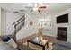 Bright living room with hardwood floors, a staircase, and a cozy fireplace with a TV mounted above at 7879 Allscott Way, Raleigh, NC 27612
