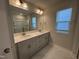 Bright bathroom featuring a double vanity with grey cabinets and a large mirror at 801 Portland Rose Dr, Knightdale, NC 27545