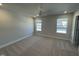 Bright bedroom, with neutral walls, ceiling fan and two windows allowing natural light at 801 Portland Rose Dr, Knightdale, NC 27545