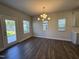 Bright dining room featuring modern chandelier, hardwood floors, and natural light at 801 Portland Rose Dr, Knightdale, NC 27545