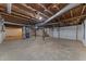 Unfinished basement featuring exposed utilities and concrete flooring with a convenient walkout at 807 New St, Graham, NC 27253