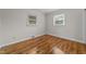 Bedroom showcasing hardwood floors, trim, and two windows with blinds at 807 New St, Graham, NC 27253