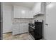 Well-lit kitchen featuring white cabinets, tile countertops, and stainless steel oven range at 807 New St, Graham, NC 27253
