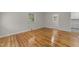 Sunlit living room with polished hardwood floors and neutral wall paint at 807 New St, Graham, NC 27253