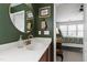 Bathroom with a white sink vanity, a round mirror, and a doorway leading to a bedroom at 818 Bryant St, Raleigh, NC 27603