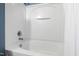 White bathtub and shower featuring a tiled surround and modern fixtures for a clean and functional design at 818 Bryant St, Raleigh, NC 27603