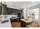 Modern kitchen with dark cabinets, stainless steel appliances, butcher block island and stylish lighting at 818 Bryant St, Raleigh, NC 27603