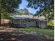 A green backyard features a deck and patio, mature trees, a wooden fence, and lush lawn at 908 E Hudson Ave, Durham, NC 27704