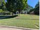 A charming home sits on a lush green lawn beneath mature trees at 908 E Hudson Ave, Durham, NC 27704