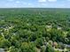 A high aerial perspective of a residential neighborhood embraced by mature trees at 9508 Waterwood Ct, Raleigh, NC 27614