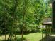 View of lush backyard landscaping and wooden deck through foliage at 9508 Waterwood Ct, Raleigh, NC 27614