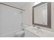 Bathroom featuring a combined tub and shower with white subway tile, a white vanity, and framed mirror at 9508 Waterwood Ct, Raleigh, NC 27614
