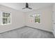 Bright bedroom with two windows, carpeted floor, neutral paint, and ceiling fan at 9508 Waterwood Ct, Raleigh, NC 27614