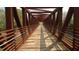 A pedestrian bridge, built with wood and steel, stretches across green foliage at 9508 Waterwood Ct, Raleigh, NC 27614
